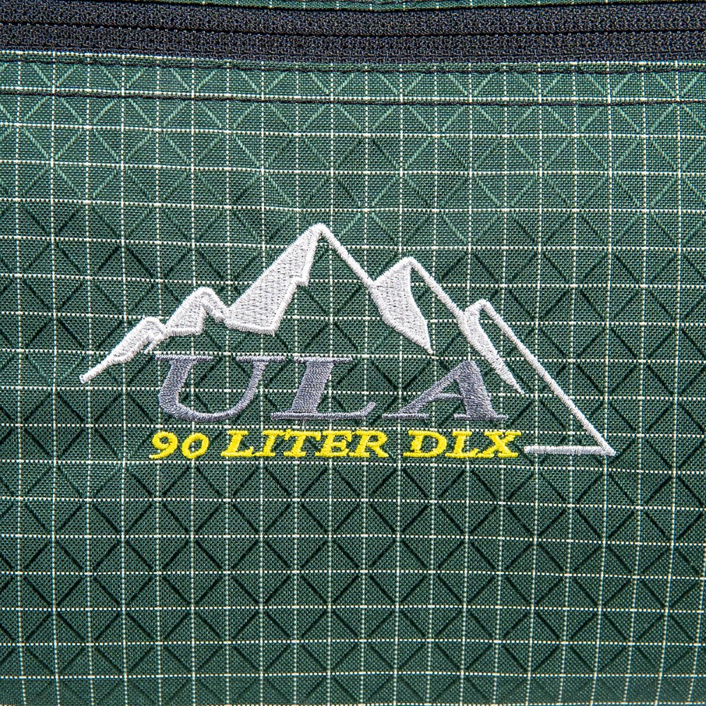 A close up of the ULA logo on the side of a ULA DLX Duffle Bag.