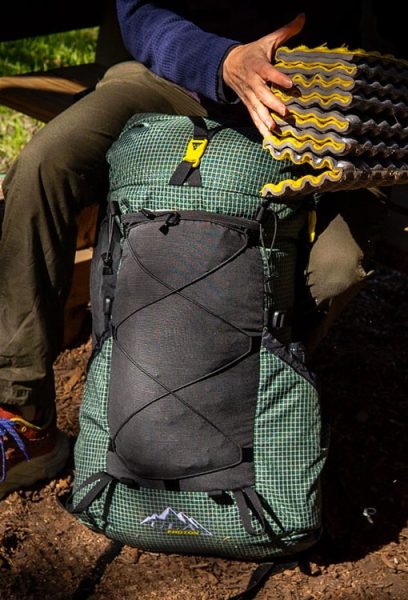 A Packer adds their foldable foam pad to their frameless ULA Photon pack.