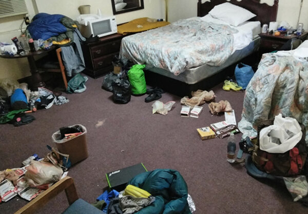 A hotel floor shows backpacks and trash from thru-hikers.