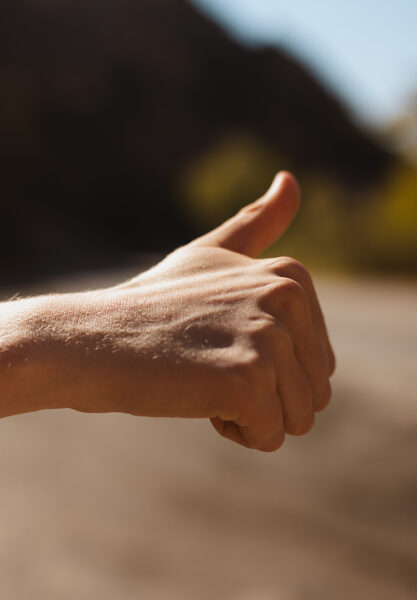 A fist with its thumb up is shown. Extend your thumb as tall as it can go.