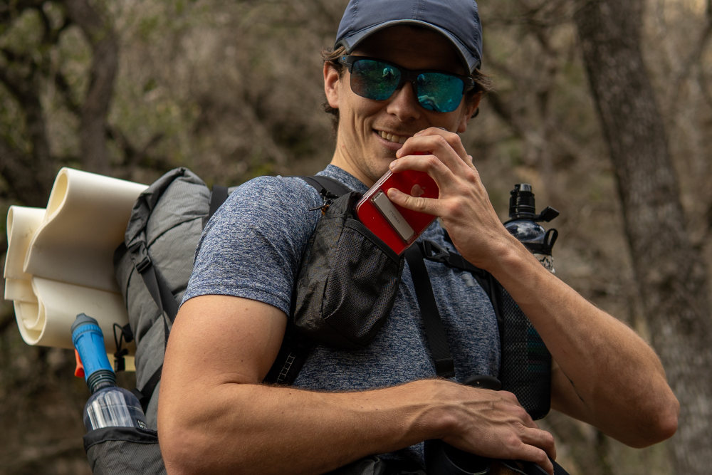 A backpacker closes their Fidlock Magnetic Sternum Strap
