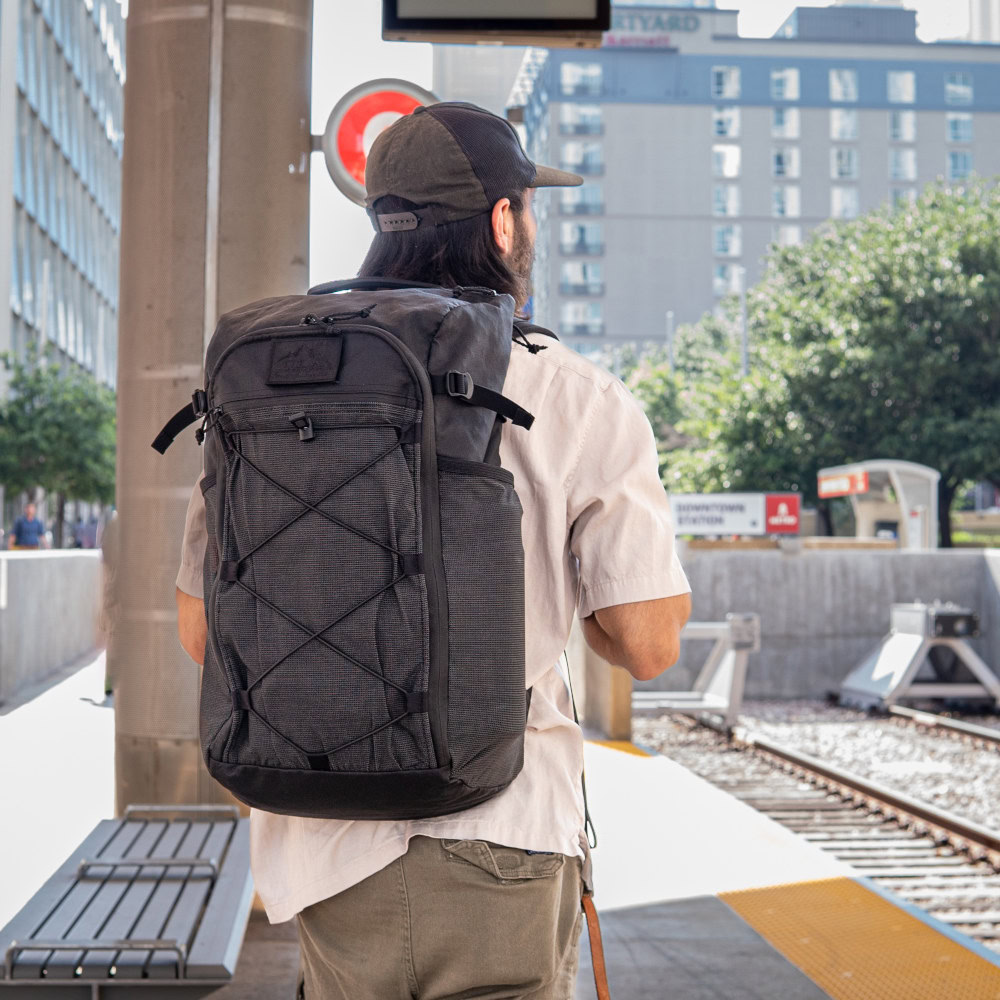 Man wears ULA EcoPak 36L Dragonfly at train station
