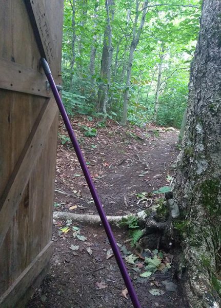 A broom handle holding open a door of a shelter on the Appalachian Trail