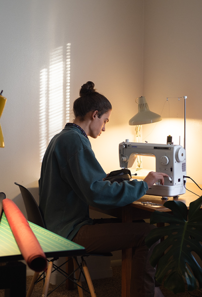Owen working at a sewing machine to make awesome gear.