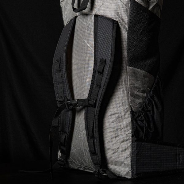 A 3/4 back view of the ULA Nexus showing the straps and sternum strap. The background is black.