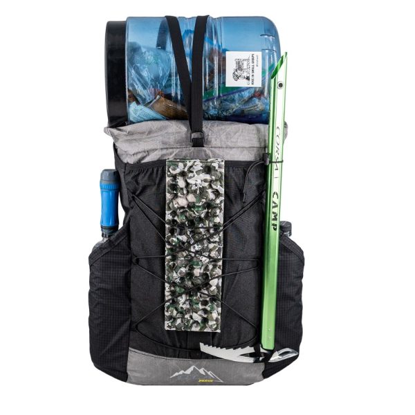 ULA Ultra X Nexus Loaded for Adventure with a water filter in the left pocket, a sleeping pad under the front cinch cord, an ice axe in the ice ax loop, water bottles in the right side pocket, and a bear bin on the top.