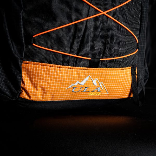 A detailed view of the bottom pannel and ULA logo on a Tangerine colored UltraGrid Nexus. The background is black.