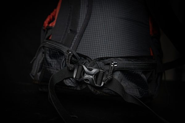 A detailed view of the Nexus hipbelt and hipbelt closure buckle. The background is black.