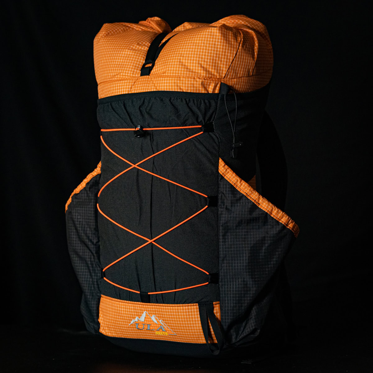 nexus tease 3-28 Backpacker reaches for his bear spray from the ULA Deploy Bear Canister Holder on his shoulder strap.