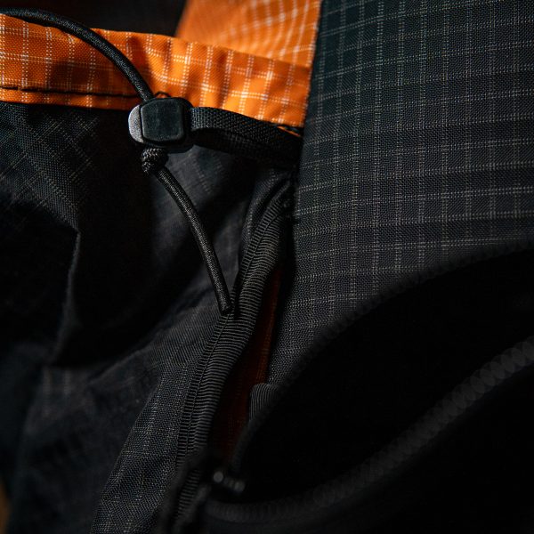 A close up of the side pocket cinch cord on the pocket of a Nexus backpack.