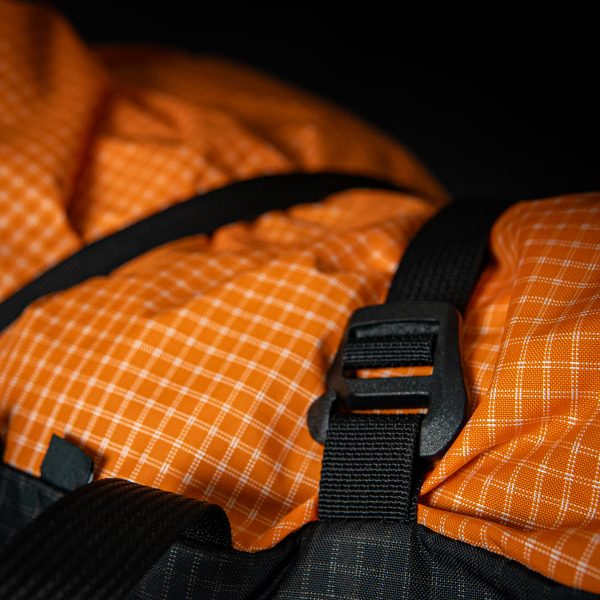 A close up of the connection clip and loop that holds a Y-strap on the top of a Nexus backpack