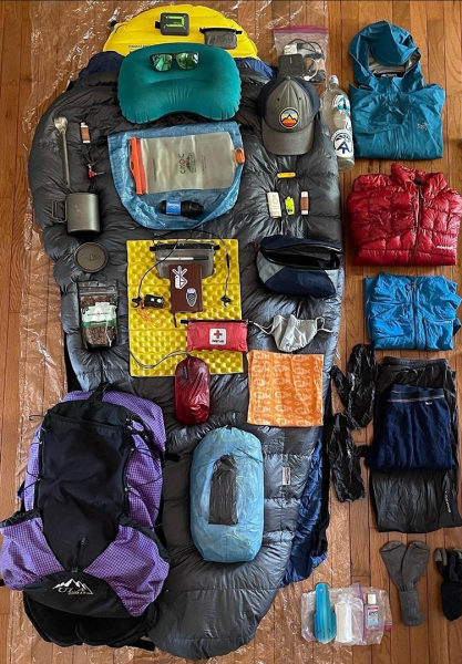An overview of everything backpacker Professor Carl puts in his ULA backpack. Image shows all gear, clothing, toiletries, emergency kit, cooking gear, and pack.