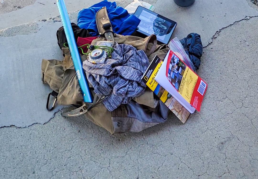 shakedown article-1 Backpacker reaches for his bear spray from the ULA Deploy Bear Canister Holder on his shoulder strap.