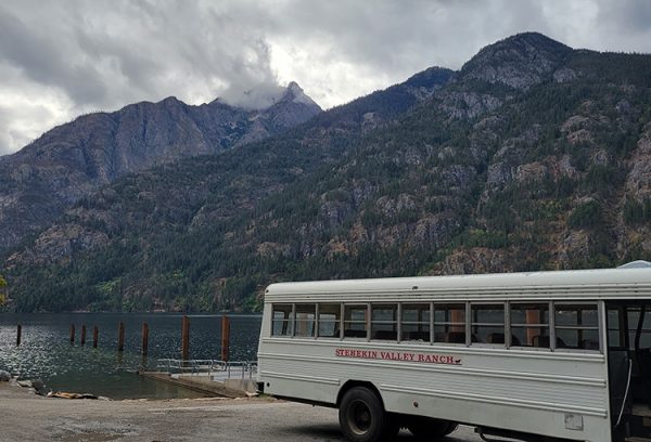 Image shows the Stehekin Valley Ranch bus next to the lake. Hikers can lodge here.