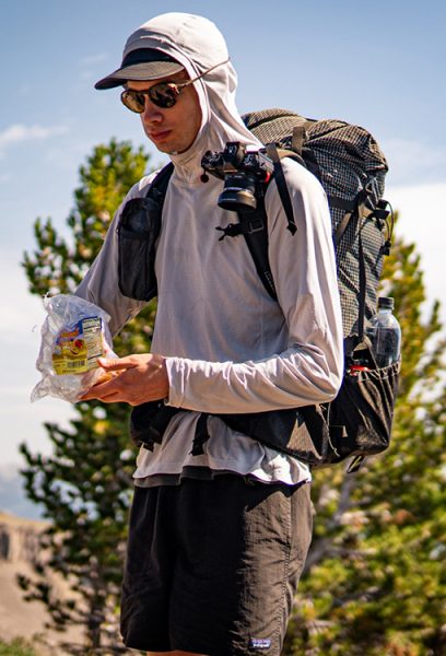 Owen, a ULA team member, is eating his trail snackies while standing.