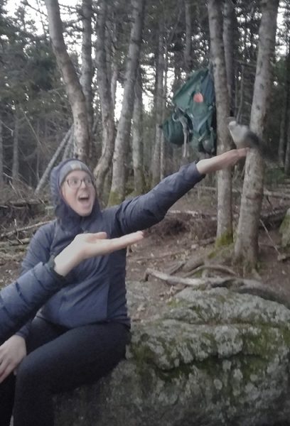 A blurry photo of two hikers feeding a bird.