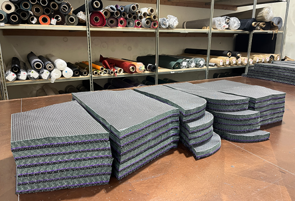 Stacks of laser cut pieces of robic fabris ready to be sewn.