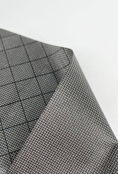 A close up view of the ULTRA 200X Fabric back (showing black diamond grid lines) and front (solid color). The fabric is a medium grey color.