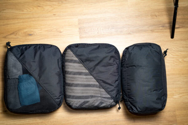 A 36L packing cube bundle of 2 large and one shoe cube sitting side by side. They are fully packed.