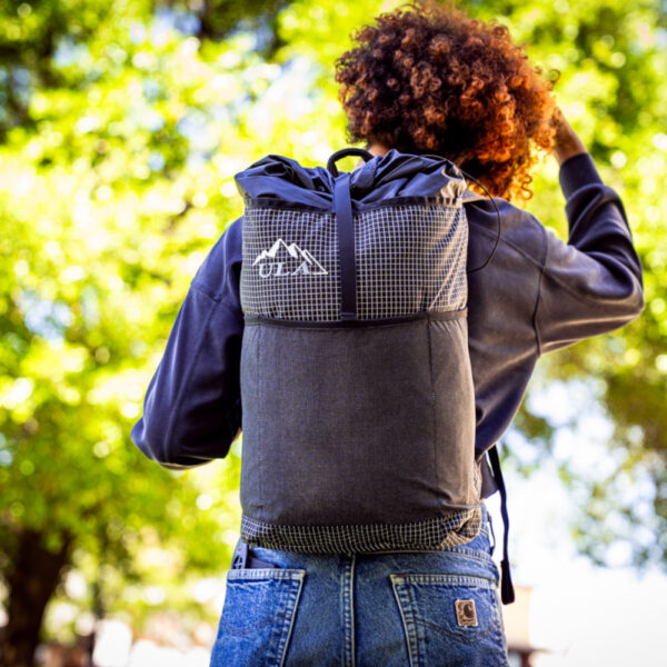 Student wears a black robic ULA Packrat Daypack, image from the back shows entire pack.