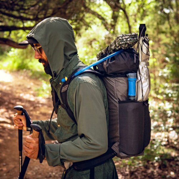 A side view of an Ultralight hiker using their ULA Packrat daypack to carry all their gear.