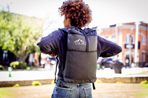 Student wears a black robic ULA Packrat Daypack, image from the back.