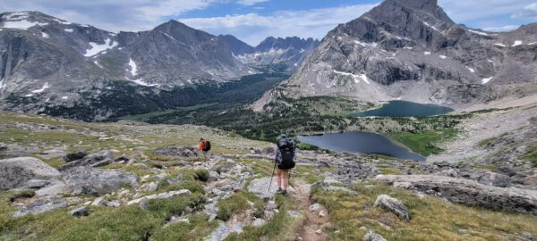 Two backpackers hike through the mountains of Wyomming.