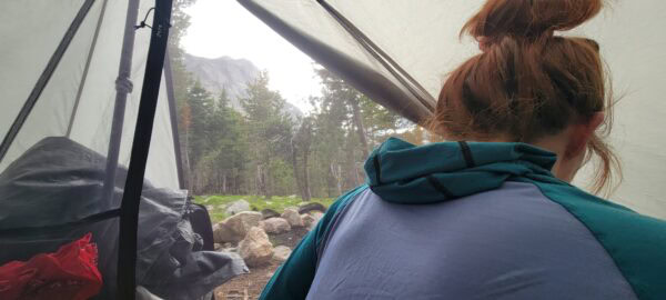 A female hiker wakes up in her tent in the Wyomming backcountry.