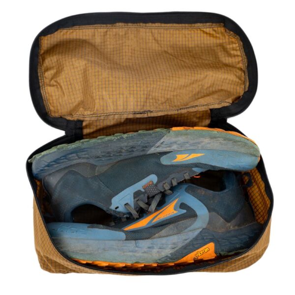 ULA Packing Shoe Cube in Coyote Brown. Cube is holding a pair of hiking shoes.