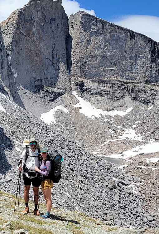 Backpacker puts a Bear Vault Bear Canister into a ULA CDT Backpack