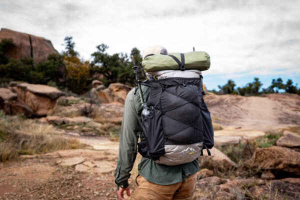 A backpacker wears the ULA Nexus backpack in the backcountry. The backpack is made of Ultra fabric.