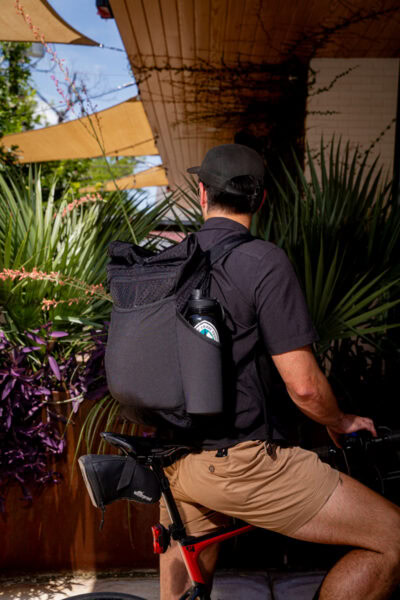 A cyclist wears a ULA Node while deciding whether or not to stop at a cafe
