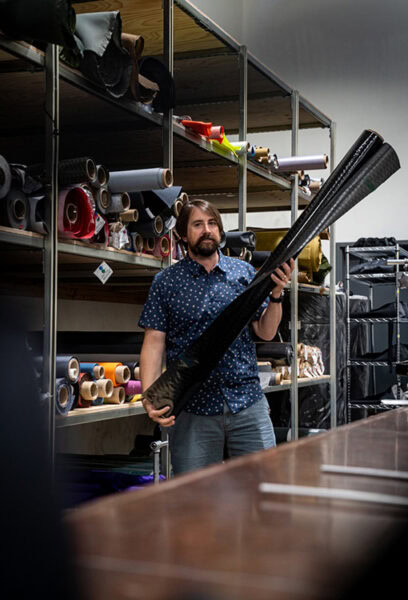 ULA owner, Peter Longobardi, pulls fabric from a shelf to construct a new ULA backpack