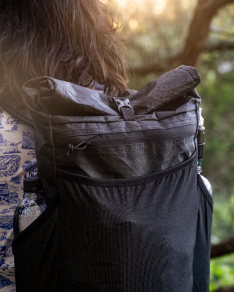 A dayhiker carries a ULA Node with two Smartwater styled bottles in the stretch mesh side pocket